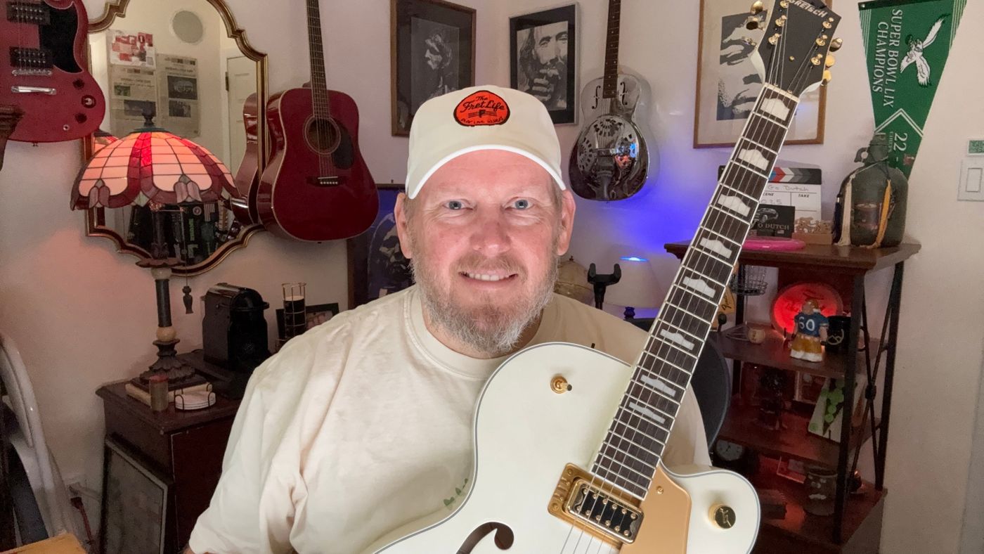 George Ruch holding a white Gretsch hollow-body guitar