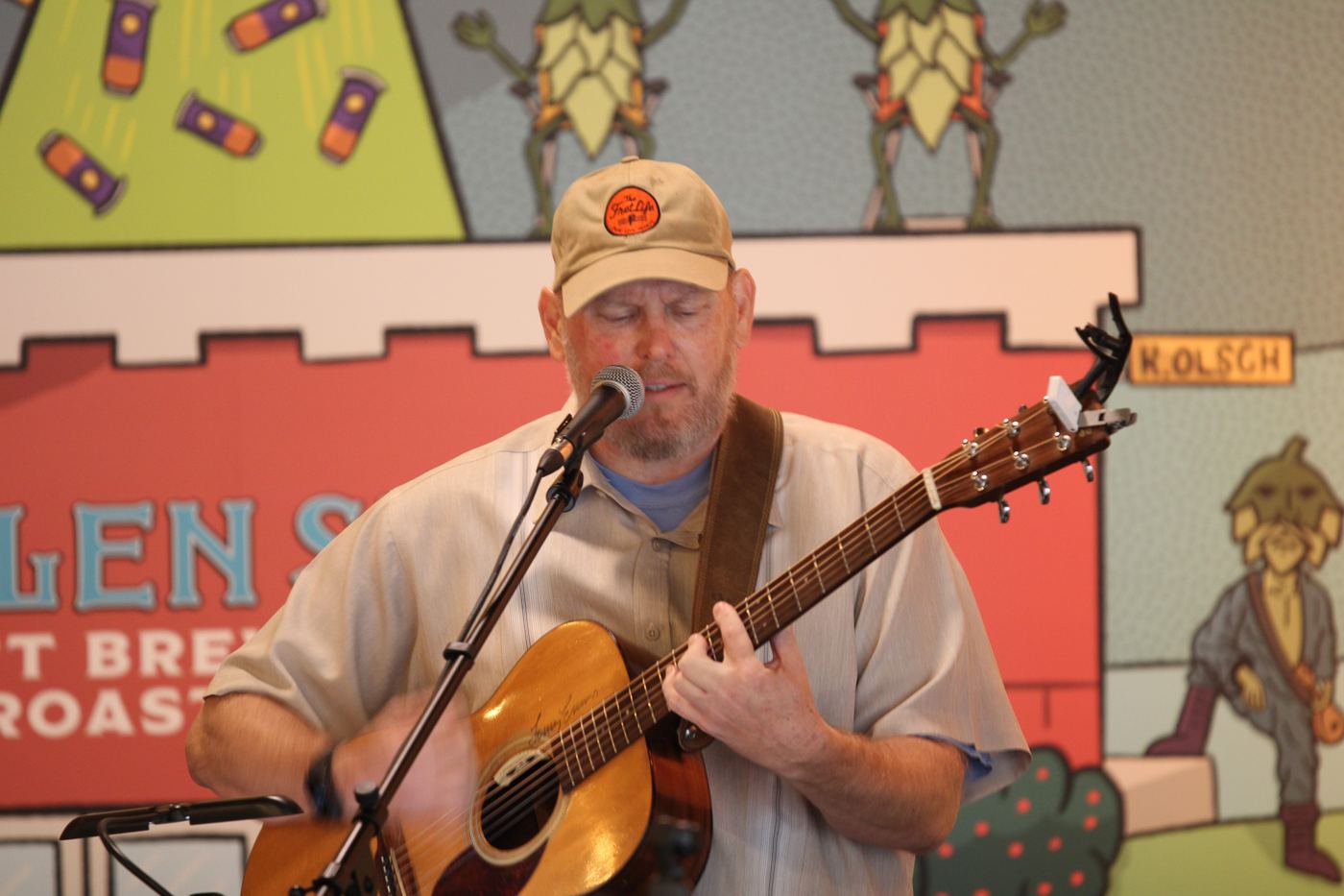 George Ruch singing and playing acoustic guitar on stage